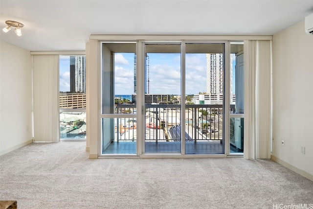carpeted spare room with floor to ceiling windows, baseboards, a wall mounted air conditioner, and a view of city