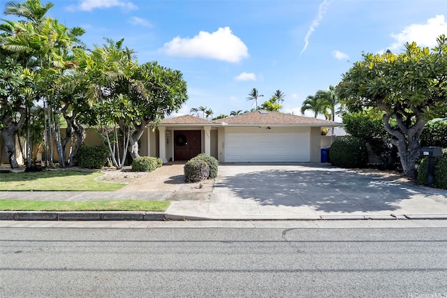 view of front of house with a garage, stucco siding, and driveway