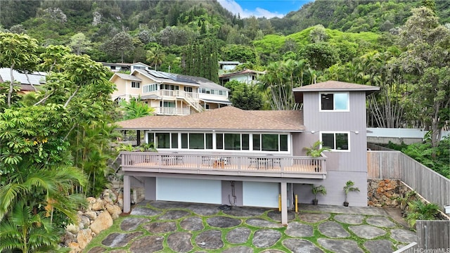 947 Uwao St Unit C, Honolulu, HI 96825 - back of property with a shingled roof, a garage, and a forest view