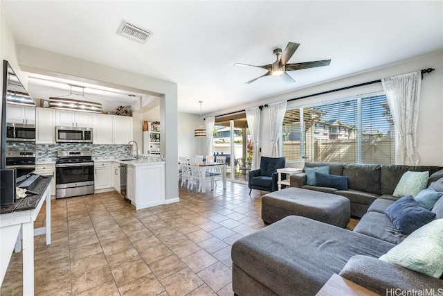 living room featuring light tile patterned floors, visible vents, and a ceiling fan