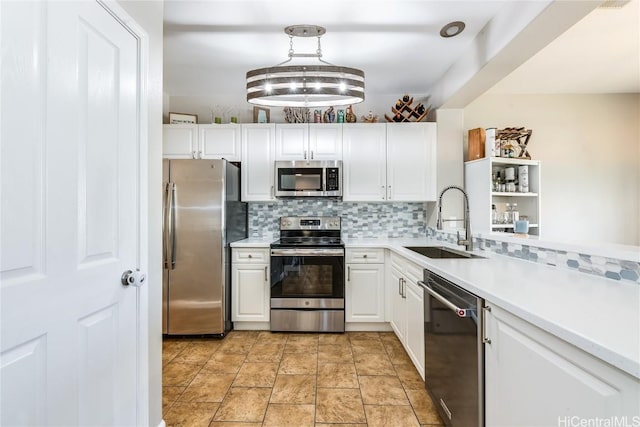 kitchen featuring a sink, light countertops, white cabinetry, stainless steel appliances, and decorative backsplash