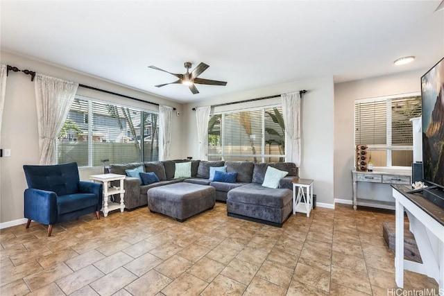 living room featuring light tile patterned floors, baseboards, and ceiling fan