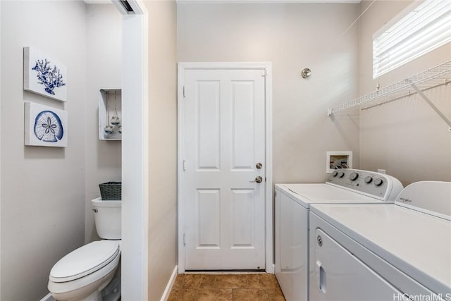 clothes washing area featuring separate washer and dryer, laundry area, and baseboards
