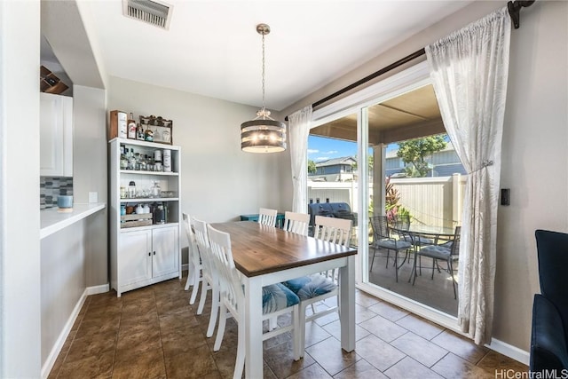 dining room with visible vents, baseboards, an inviting chandelier, and dark tile patterned flooring