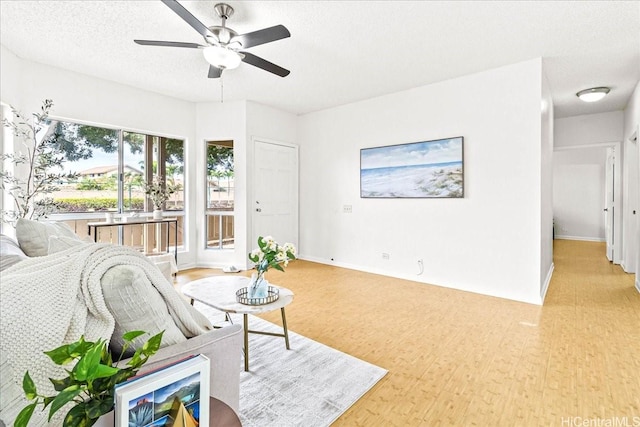 91-490 Puamaeole St Unit 46C, Ewa Beach, HI 96706 - living room featuring light wood-type flooring, ceiling fan, a textured ceiling, and baseboards