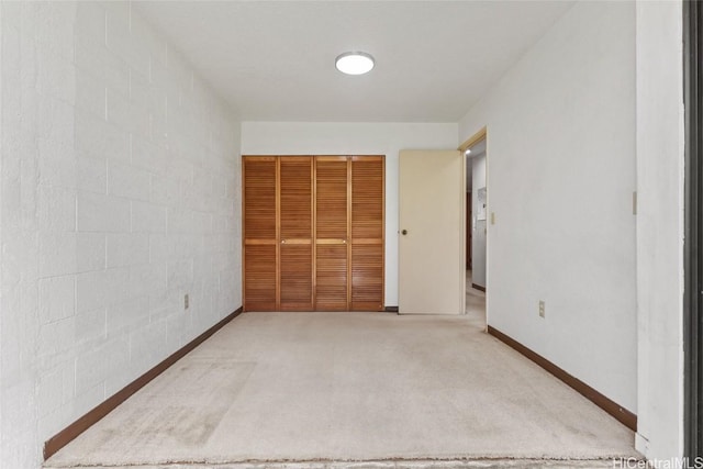 unfurnished bedroom featuring a closet, baseboards, and carpet