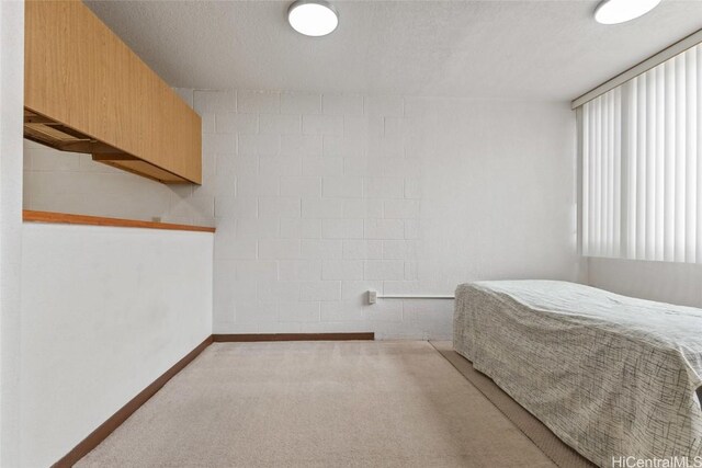 carpeted bedroom with baseboards and a textured ceiling