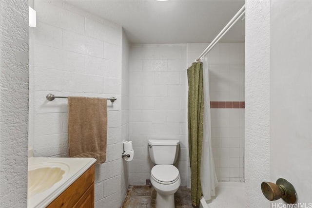 full bathroom with vanity, toilet, and tiled shower