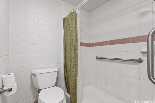 bathroom featuring toilet and a shower stall
