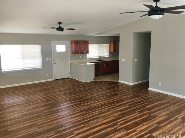unfurnished living room with dark wood finished floors, baseboards, vaulted ceiling, and a ceiling fan