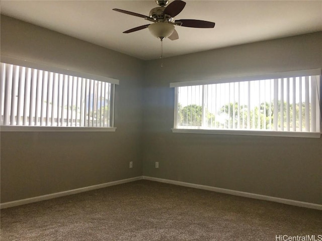 carpeted spare room featuring a ceiling fan and baseboards