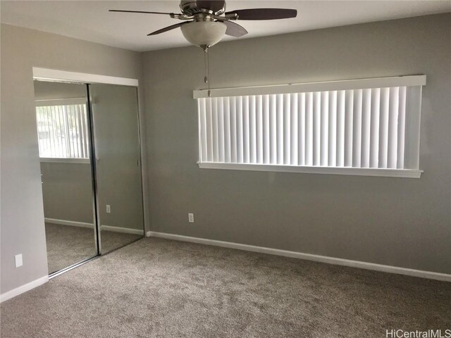 unfurnished bedroom with a closet, carpet floors, ceiling fan, and baseboards