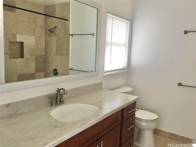 bathroom featuring toilet, tile patterned floors, a shower, and vanity