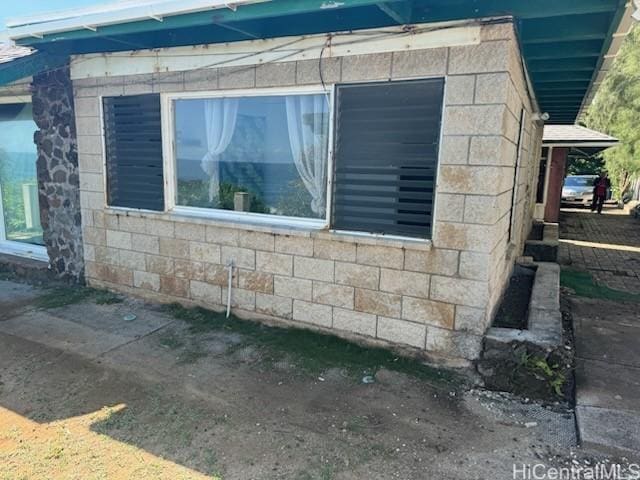 view of home's exterior with concrete block siding and stone siding