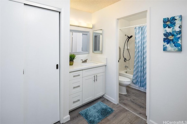 full bath featuring shower / bath combo, a textured ceiling, wood finished floors, toilet, and vanity