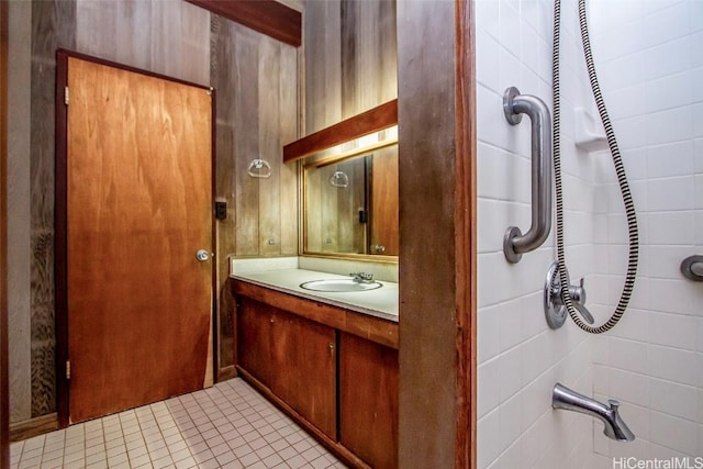 bathroom with tile patterned flooring, vanity, and walk in shower