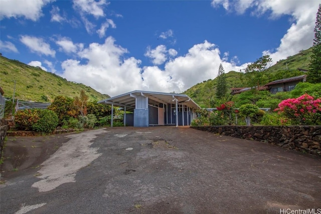 exterior space featuring an attached carport, driveway, and a mountain view