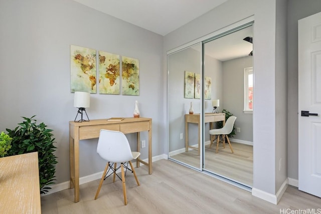 office space with baseboards and wood finished floors