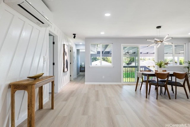 dining space with baseboards, recessed lighting, light wood-style flooring, and an AC wall unit