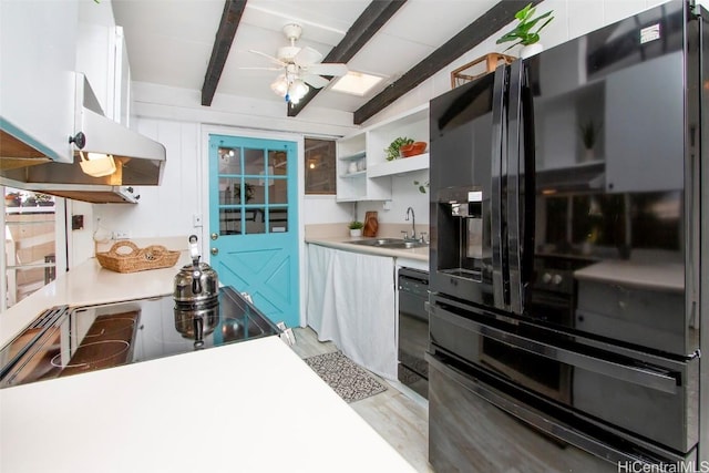 kitchen featuring a sink, open shelves, beamed ceiling, black appliances, and ceiling fan