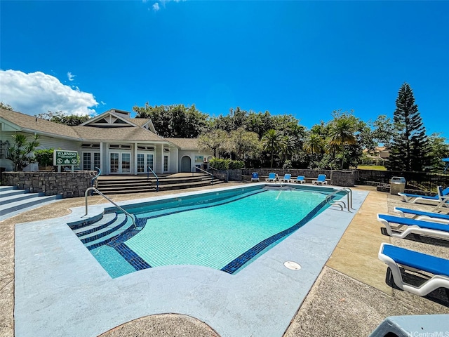 pool featuring fence, a patio, and french doors