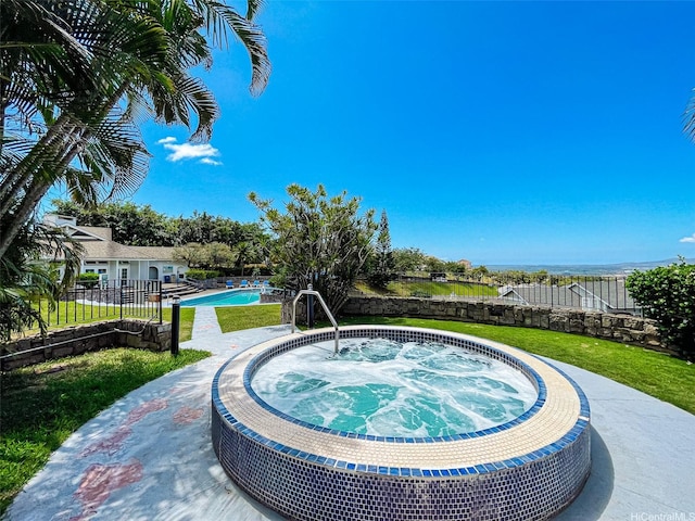 pool featuring a yard, an in ground hot tub, and a fenced backyard