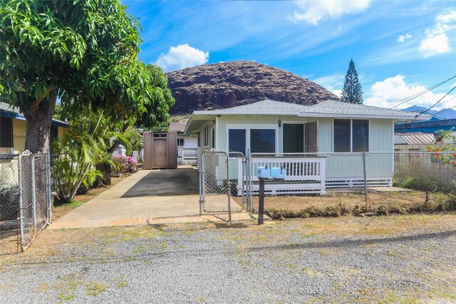 87-118 Alapaki St, Waianae, HI 96792 - view of front of property featuring a gate, a fenced front yard, driveway, a mountain view, and covered porch