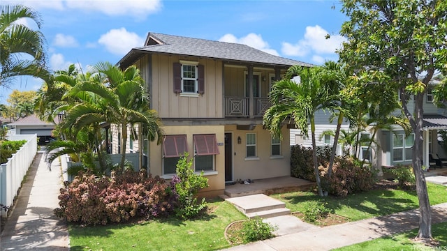 91-1036 Kaiuliuli St, Ewa Beach, HI 96706 - view of property featuring a front lawn, a balcony, a shingled roof, and board and batten siding
