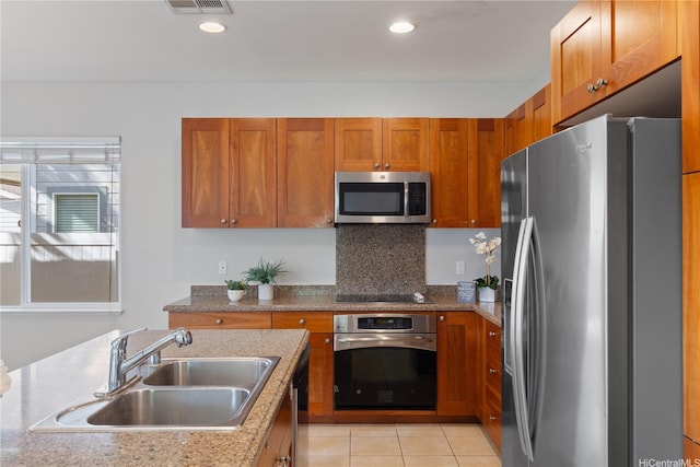 91-1036 Kaiuliuli St, Ewa Beach, HI 96706 - kitchen featuring stainless steel appliances, a sink, brown cabinets, decorative backsplash, and light tile patterned floors