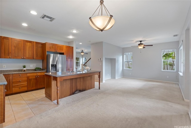 91-1036 Kaiuliuli St, Ewa Beach, HI 96706 - kitchen featuring stainless steel fridge, ceiling fan, brown cabinetry, baseboards, and light carpet