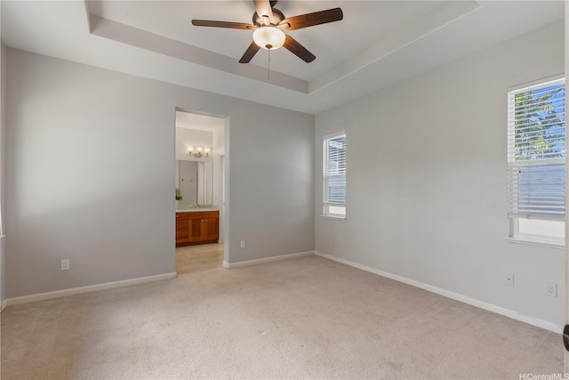 91-1036 Kaiuliuli St, Ewa Beach, HI 96706 - empty room featuring a tray ceiling, light colored carpet, healthy amount of natural light, and ceiling fan