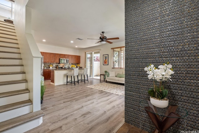 91-6221 Kapolei Pkwy Unit 511, Ewa Beach, HI 96706 - living area with stairs, recessed lighting, a ceiling fan, light wood-style flooring, and baseboards