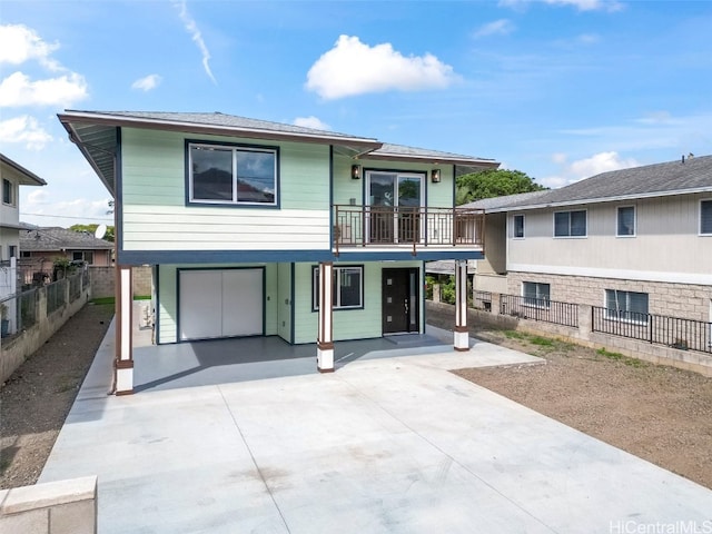 view of front of property featuring fence, an attached garage, and concrete driveway