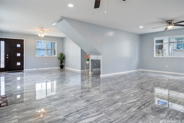 unfurnished living room with marble finish floor, a ceiling fan, baseboards, and recessed lighting