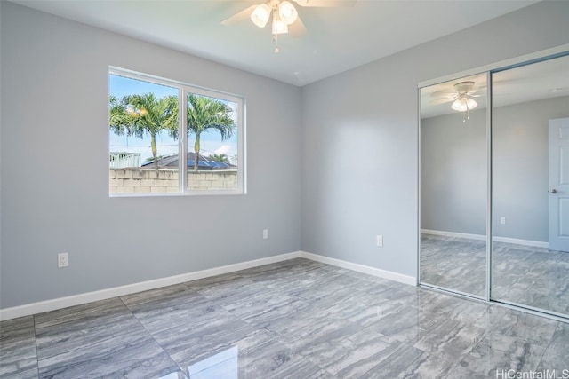 unfurnished bedroom with a closet, baseboards, and a ceiling fan