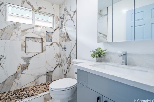 full bath with toilet, vanity, and a marble finish shower