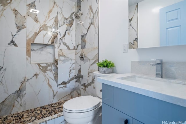 bathroom featuring toilet, vanity, and a marble finish shower
