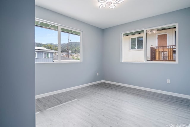 unfurnished room with baseboards and wood finished floors