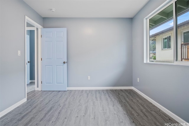 empty room with baseboards and wood finished floors