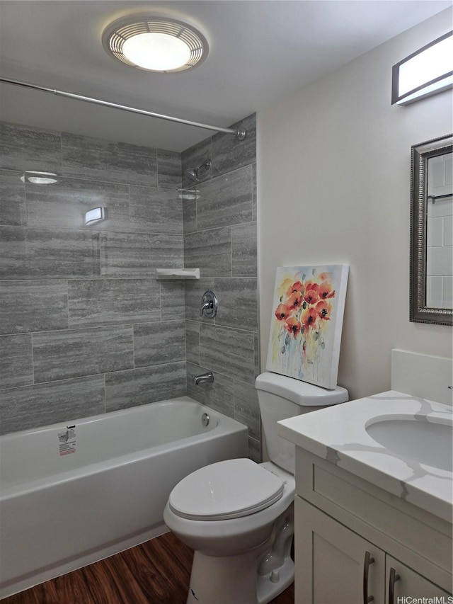 full bath featuring bathing tub / shower combination, wood finished floors, vanity, and toilet