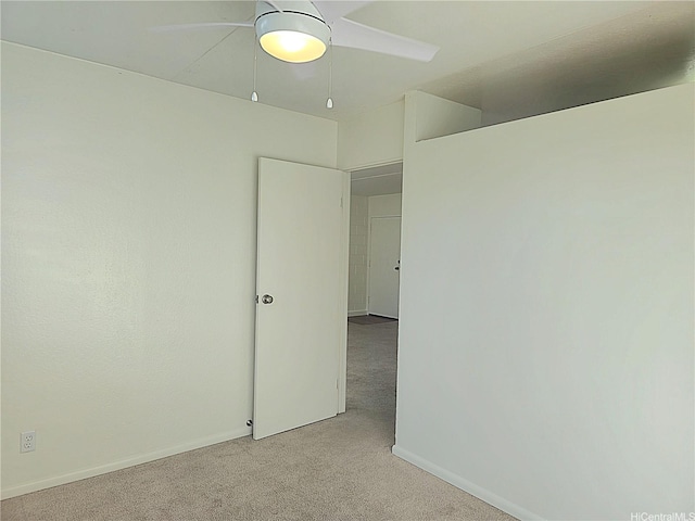 unfurnished room featuring light carpet, baseboards, and ceiling fan
