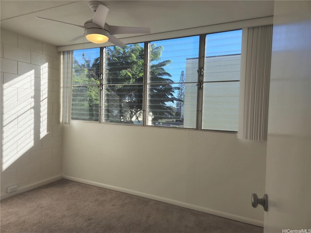 carpeted spare room with baseboards and ceiling fan
