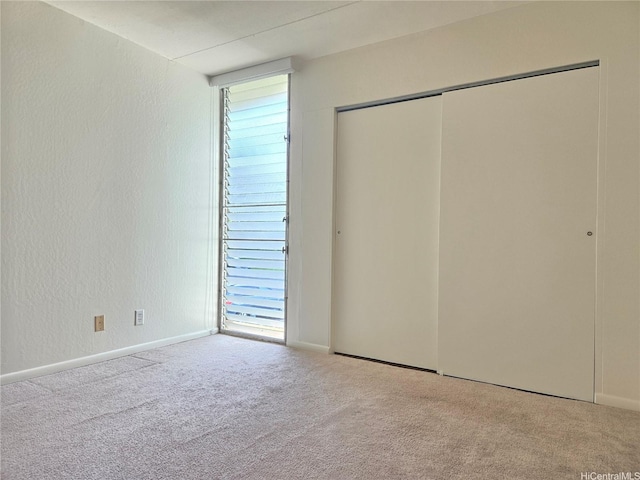 95-029 Kuahelani Ave Unit 331, Mililani, HI 96789 - unfurnished bedroom featuring carpet floors, multiple windows, and a closet