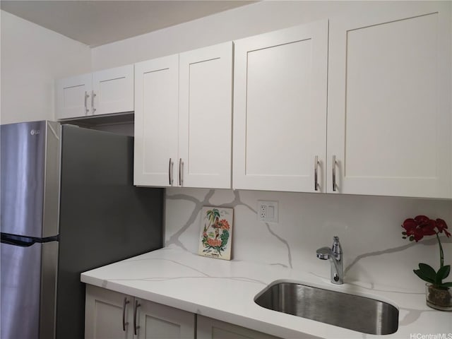 95-029 Kuahelani Ave Unit 331, Mililani, HI 96789 - kitchen with freestanding refrigerator, light stone counters, and white cabinetry