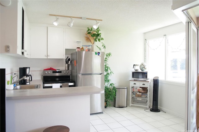1330 Wilder Ave Unit 314, Honolulu, HI 96822 - kitchen featuring light countertops, white cabinets, a sink, light tile patterned floors, and stainless steel appliances