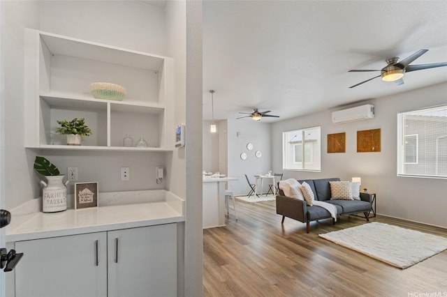 91-3575 Iwikuamoo St Unit 405, Ewa Beach, HI 96706 - living room with a ceiling fan, a wall mounted air conditioner, and wood finished floors