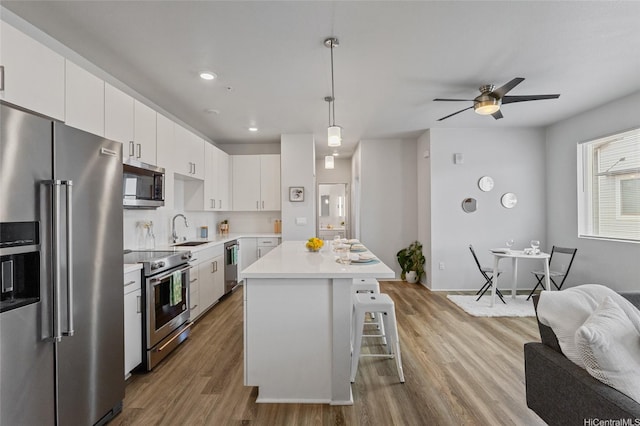 91-3575 Iwikuamoo St Unit 405, Ewa Beach, HI 96706 - kitchen with stainless steel appliances, a sink, light countertops, open floor plan, and wood finished floors