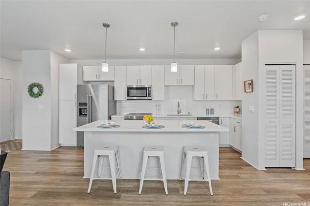 91-3575 Iwikuamoo St Unit 405, Ewa Beach, HI 96706 - kitchen featuring stainless steel appliances, a breakfast bar, a kitchen island, light countertops, and white cabinets