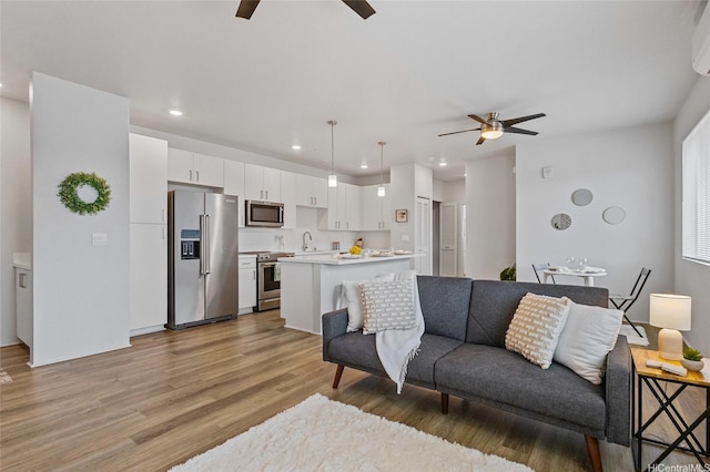 91-3575 Iwikuamoo St Unit 405, Ewa Beach, HI 96706 - living area featuring a ceiling fan, light wood-style flooring, recessed lighting, and a wall unit AC