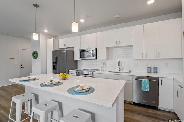 91-3575 Iwikuamoo St Unit 405, Ewa Beach, HI 96706 - kitchen featuring appliances with stainless steel finishes, a breakfast bar area, dark wood-style flooring, light countertops, and tasteful backsplash